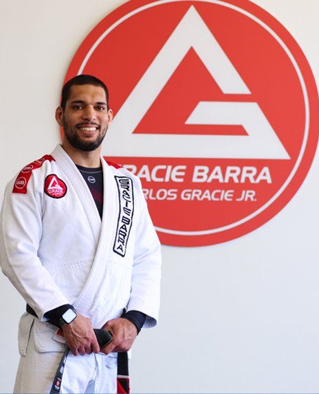 Prof. Seidler Rodrigo standing besides Gracie Barra Utah logo