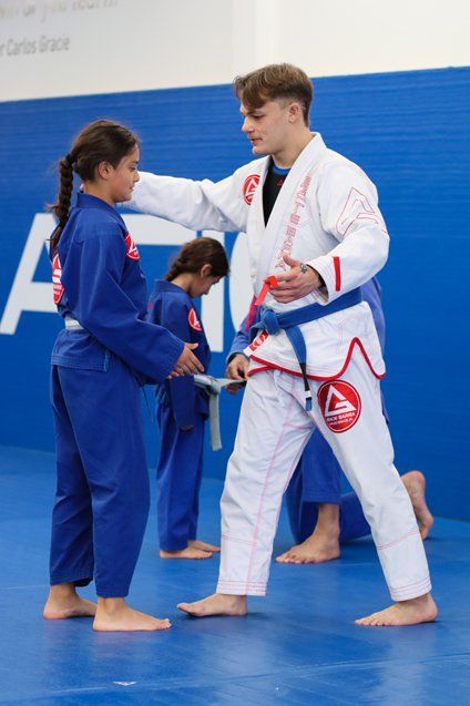 A girl on her first BJJ class with a blue belt