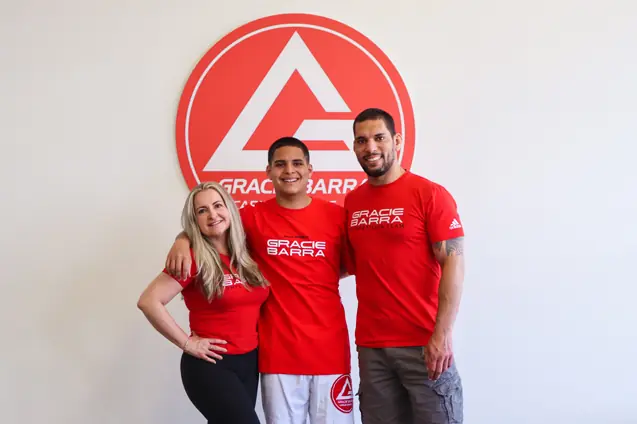 Daniela, coach Pedro and Prof Seidler Rodrigo posing at Gracie Barra sign