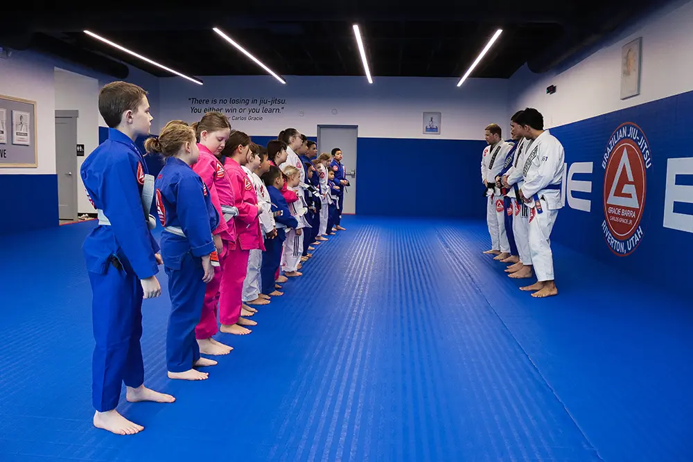 An instructor coaching a student during class at Gracie Barra Riverton