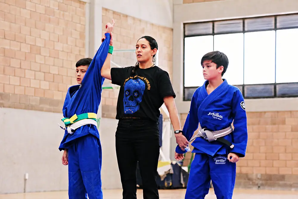 Referee raising the hand of a young athlete at a youth Jiu-Jitsu competition in Mexico